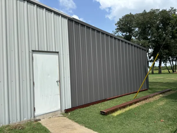 Grey metal siding panels with a white walk door, Pottsboro, TX