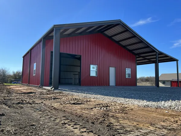 Red metal barn with a covered side bay, Howe, TX