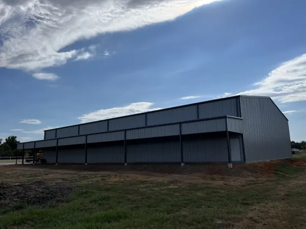 Dark grey pre-engineered steel building with a lean-to, Howe, TX