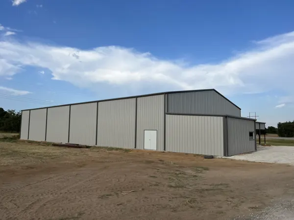 White pre-engineered steel building with a walk door, Howe, TX