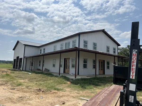 Long white metal building with a wrap-around porch, Van Alstyne, TX