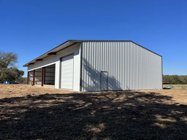 White bolt-up metal building with a lean-to and roll-up door, Van Alstyne, TX