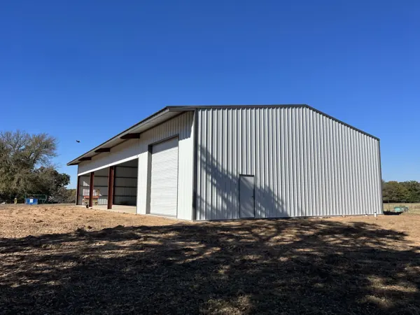 White steel building kit with a red door, Van Alstyne, TX