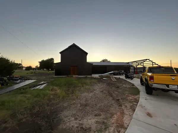 Metal building at dusk with the delivery truck leaving the site, Sherman, TX