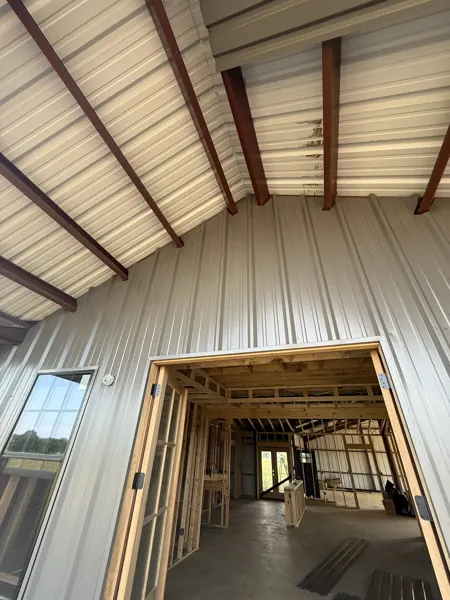 Metal roof panels over timber framing inside a barn, Sherman, TX