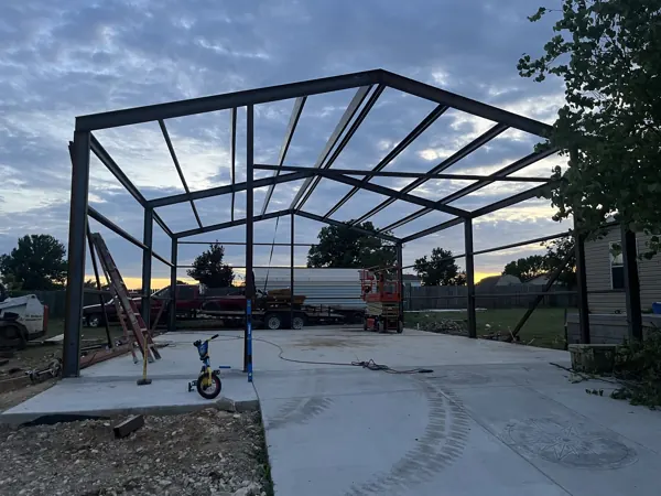 Steel frame at dusk with a lift on the slab, Sherman, TX