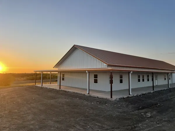 Barndominium at sunrise with a full-length porch, Howe, TX