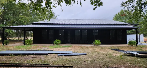 Black metal building with an R-Panel roof, Sherman, TX