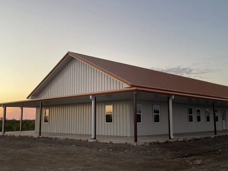 Finished metal barndominium with wraparound porch in North Texas